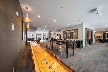 A long wooden table with several stools is in the middle of a room.